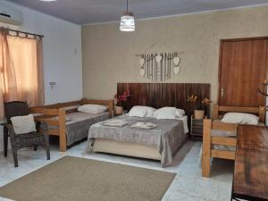 a bedroom with two beds and a table and chairs at Pousada da Aline in Sete Barras