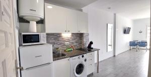 a kitchen with a white refrigerator and a washer and dryer at Benal Beach Vibe in Benalmádena