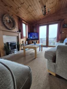 a living room with a couch and a table and a tv at Surf Lodge in West Down