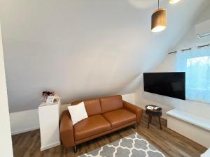 a living room with a couch and a television at CityApartments Residence klimatisiert in Friedrichshafen
