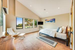 a bedroom with a bed and a couch and windows at Seaspray in Sea Ranch