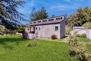 an old wooden building in a grassy yard at Loon's Landing in Sea Ranch
