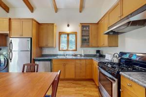 a kitchen with wooden cabinets and a wooden table at Loon's Landing in Sea Ranch
