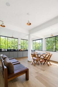 a living room with a table and chairs and windows at Morada dos Ventos Búzios in Búzios