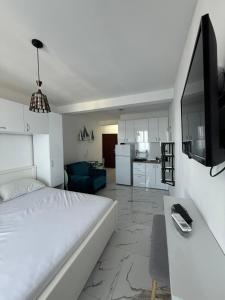 a white bedroom with a large bed and a kitchen at Duo Apartments in Bar