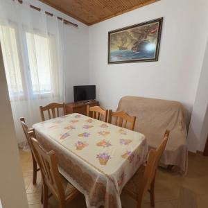 a dining room with a table and chairs and a television at Orikum Holiday Apartaments in Orikum