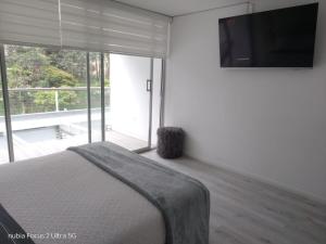 a bedroom with a bed and a flat screen tv at Room cerca al aeropuerto #1 in Bogotá