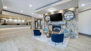 a lobby with a fireplace and a tv on a stone wall at Sandman Hotel & Suites Kelowna in Kelowna