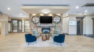 a lobby with a fireplace and a flat screen tv at Sandman Hotel & Suites Kelowna in Kelowna