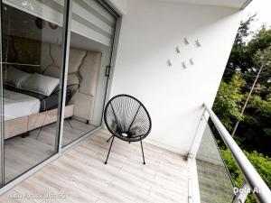 a room with a bed and a chair on a balcony at Room cerca al aeropuerto #1 in Bogotá