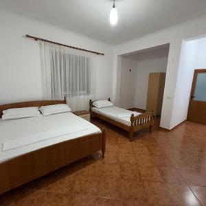 a bedroom with two beds and a window at Orikum Holiday Apartaments in Orikum