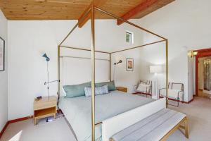 a bedroom with a canopy bed with a wooden ceiling at Hilma House in Sea Ranch