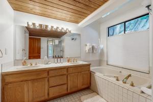 a bathroom with a tub and a sink and a tub and a mirror at Hilma House in Sea Ranch +30 photos