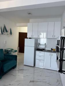 a kitchen with white cabinets and a white refrigerator at Duo Apartments in Bar