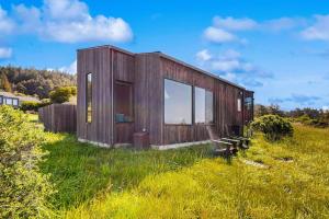 a small wooden house in a field of grass at Wild Meadow in Sea Ranch