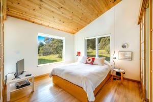 a bedroom with a bed and a large window at Madrone Cottage in Sea Ranch