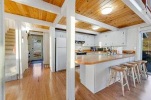 a kitchen with white cabinets and a wooden ceiling at Otter's Rest in Gualala