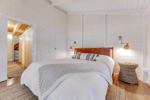 a white bedroom with a large bed and a hallway at Otter's Rest in Gualala