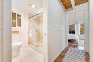 a white bathroom with a toilet and a shower at Otter's Rest in Gualala