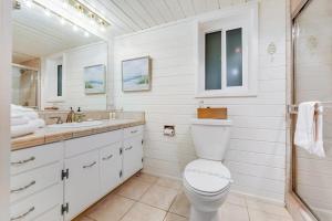 a white bathroom with a toilet and a sink at Otter's Rest in Gualala