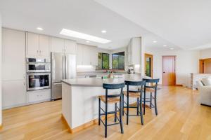 a kitchen with white cabinets and bar stools at Heron's Nest in Sea Ranch