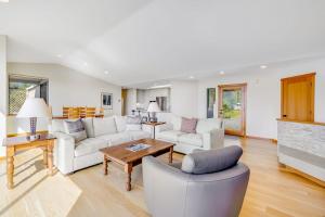 a living room with white furniture and a fireplace at Heron's Nest in Sea Ranch
