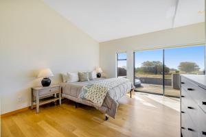 a bedroom with a bed and a large window at Heron's Nest in Sea Ranch +17 photos