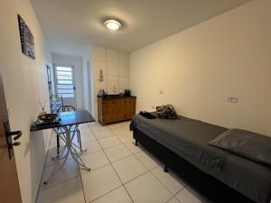 a bedroom with a bed and a table in it at SJ Suites in São José dos Pinhais