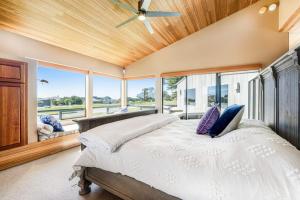 a bedroom with a large bed with a ceiling fan at Da Yaya House in Sea Ranch