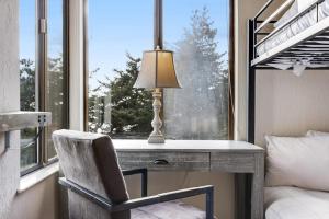 a desk with a lamp and a chair in front of a window at Greencroft Meadows in Sea Ranch