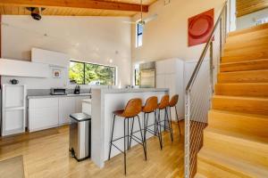 a kitchen with white cabinets and a counter with stools at SeaRenity in Sea Ranch