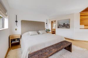 a bedroom with a large bed and a wooden bench at Sequoia Vista in Gualala