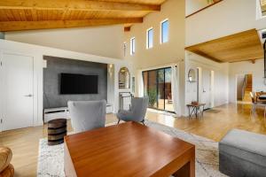 a living room with a table and a tv at SeaRenity in Sea Ranch