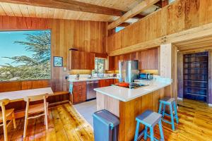 a large kitchen with wooden walls and wooden floors at Dune Drift in Sea Ranch