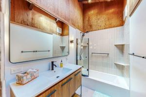 a bathroom with a sink and a tub and a mirror at Dune Drift in Sea Ranch