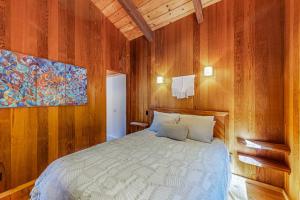 a bedroom with a bed in a wooden wall at Dune Drift in Sea Ranch