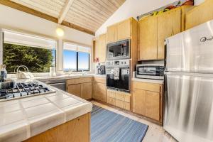 a kitchen with stainless steel appliances and wooden cabinets at Urban Escape Compound in Sea Ranch