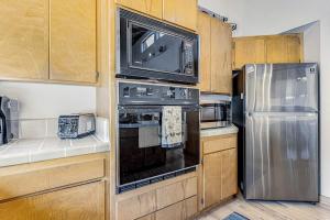 a kitchen with a stainless steel refrigerator and a microwave at Urban Escape Compound in Sea Ranch +31 photos