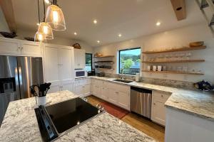 a kitchen with white cabinets and marble counter tops at Coastal Calm at Sea Ranch in Sea Ranch