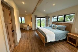 a bedroom with a bed and a couch and windows at Coastal Calm at Sea Ranch in Sea Ranch