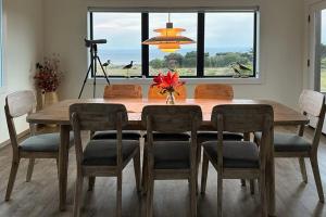 a dining room table with chairs and a large window at Coastal Calm at Sea Ranch in Sea Ranch +37 photos