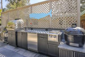 a outdoor kitchen with a grill and a grill at Eagle's Landing - Main House & Studio in Gualala