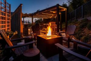 a fire pit sitting on a patio with chairs at Eagle's Landing - Main House in Gualala