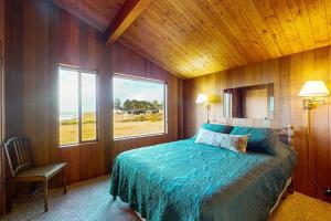 a bedroom with a bed and a large window at Touch the Tides in Sea Ranch