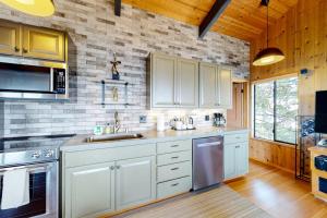 a kitchen with white cabinets and stainless steel appliances at Eagle's Landing - Main House in Gualala