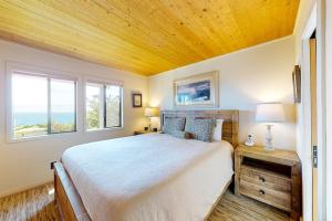 a bedroom with a bed and two windows at Eagle's Landing - Main House in Gualala