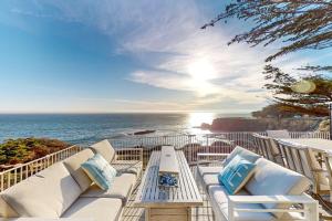 a balcony with white furniture and a view of the ocean at Oceanfront Dream Hideaway in Gualala