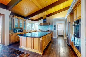 a large kitchen with wooden cabinets and a large island at Oceanfront Dream Hideaway in Gualala