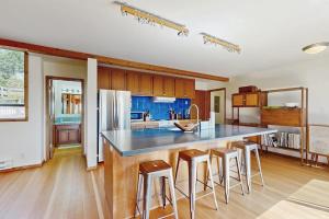 a kitchen with a island with bar stools in it at Timber & Tide in Sea Ranch