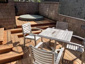 a wooden table and chairs on a wooden deck at Madrone Meadow in Sea Ranch